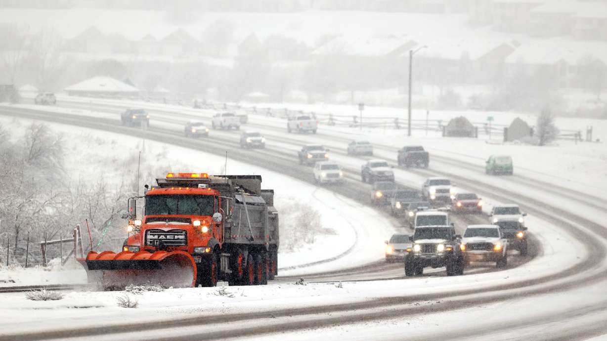 A snow plow clears 12300 South in Riverton during a snowstorm on Dec. 10, 2022.