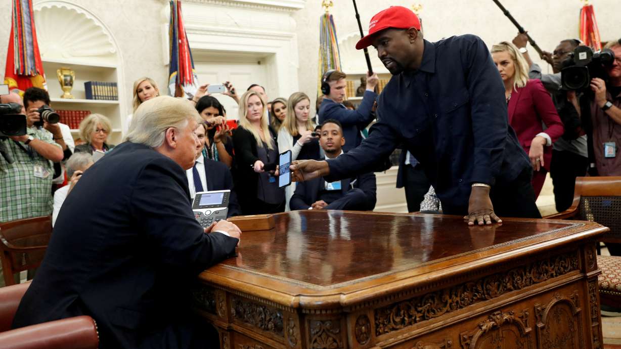 Rapper Kanye West shows President Donald Trump his mobile phone during a meeting in the Oval Office at the White House in Washington, Oct. 11, 2018.
