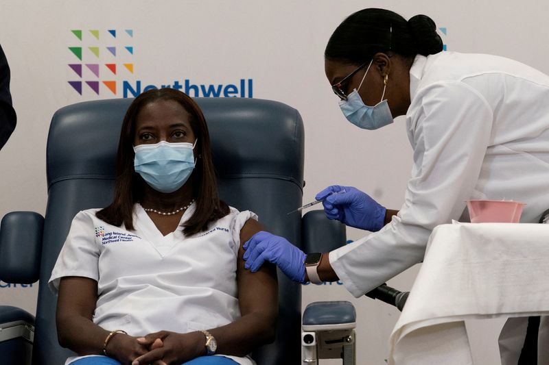 Sandra Lindsay, a nurse at Long Island Jewish Medical Center, is inoculated with the coronavirus vaccine by Dr. Michelle Chester from Northwell Health at Long Island Jewish Medical Center in New Hyde Park, New York, Dec. 14, 2020.