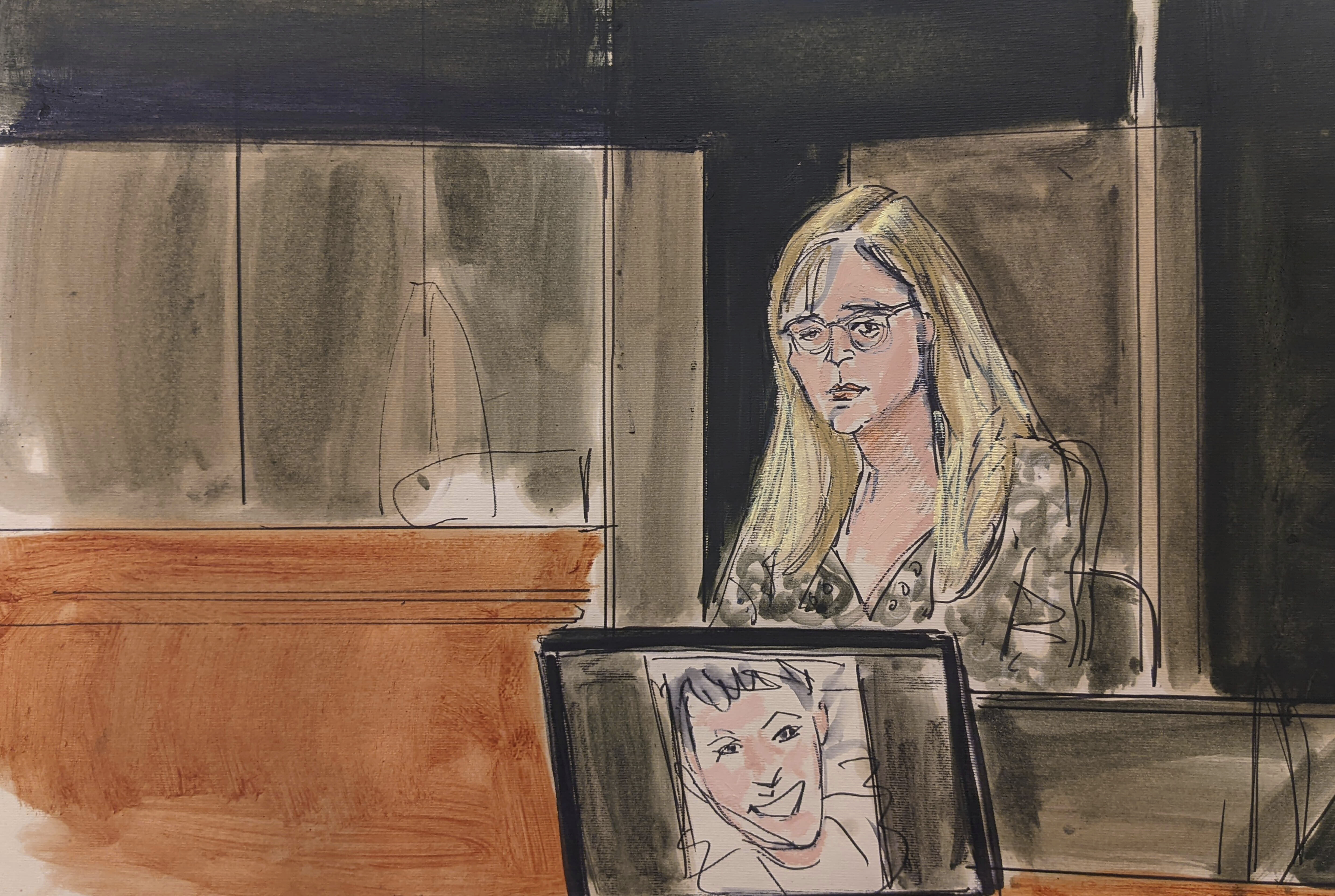 In this courtroom sketch, Annie Farmer testifies on the witness stand during the Ghislaine Maxwell sex abuse trial, Friday, in New York. A photo of Maxwell appears on a screen at foreground.