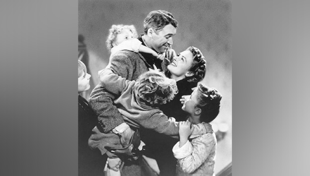 This image released by Paramount Home Entertainment shows child actor Karolyn Grimes on the back of Jimmy Stewart in a scene from the holiday classic "It's a Wonderful Life," also starring Donna Reed. The film is celebrating its 75th anniversary.