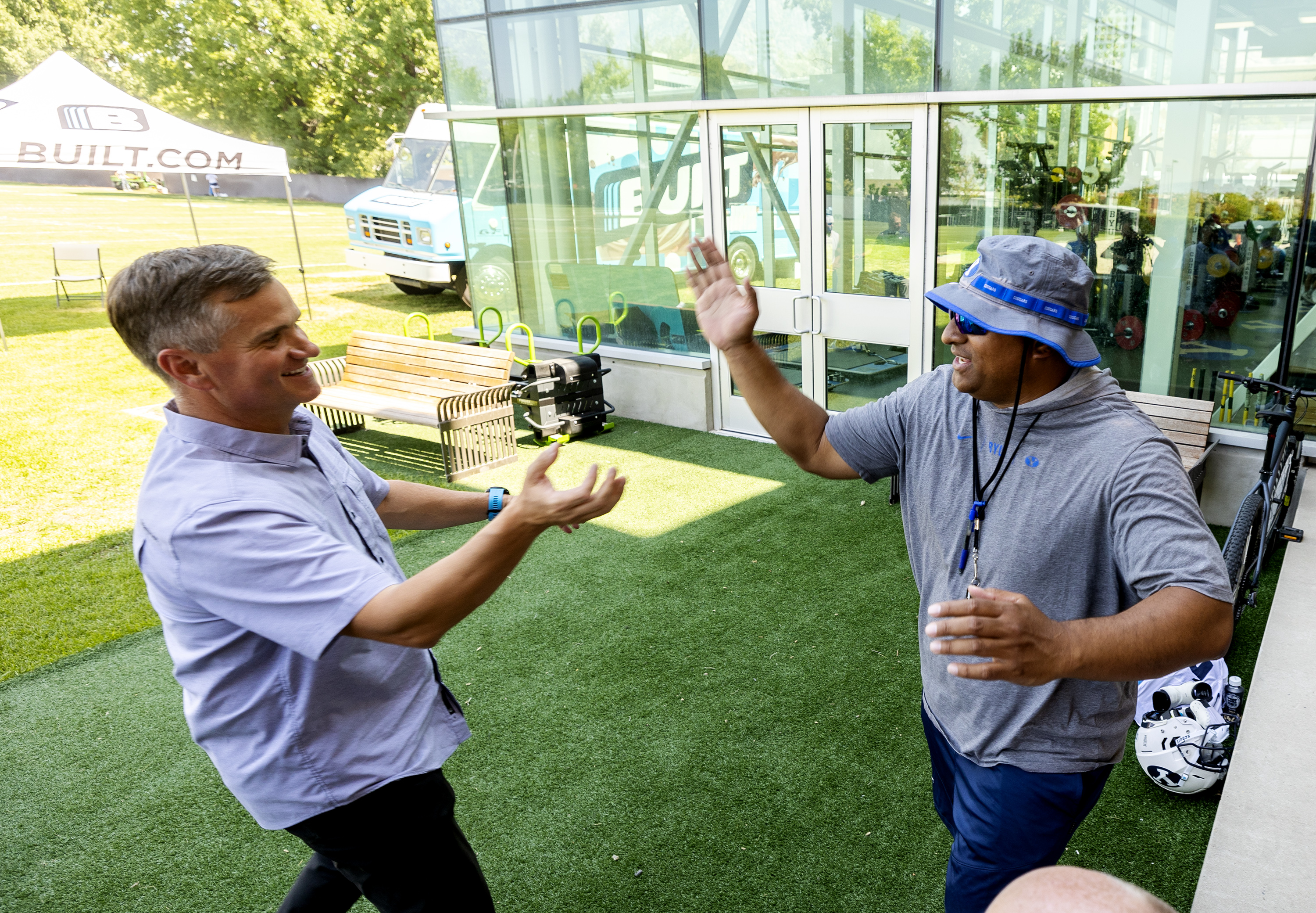 Nick Greer, co-founder of Built Brands, left, and BYU football coach Kalani Sitake greet each other during a press conference at the BYU Student Athlete Building in Provo on Friday, Aug. 13, 2021, where they discussed Built Brands’ name, image and likeness agreement with BYU.