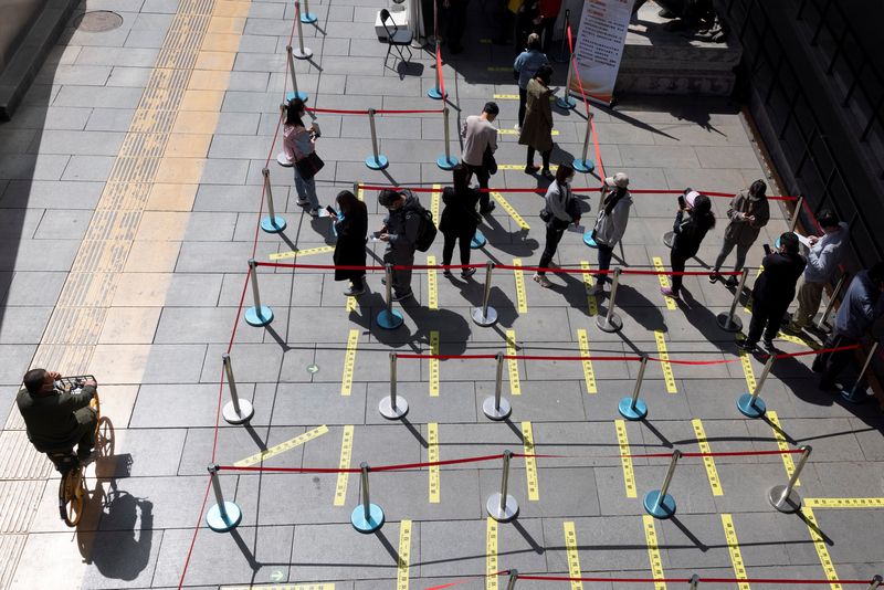 People line up at a coronavirus disease mobile vaccination unit in Beijing, China, April 14, 2021.