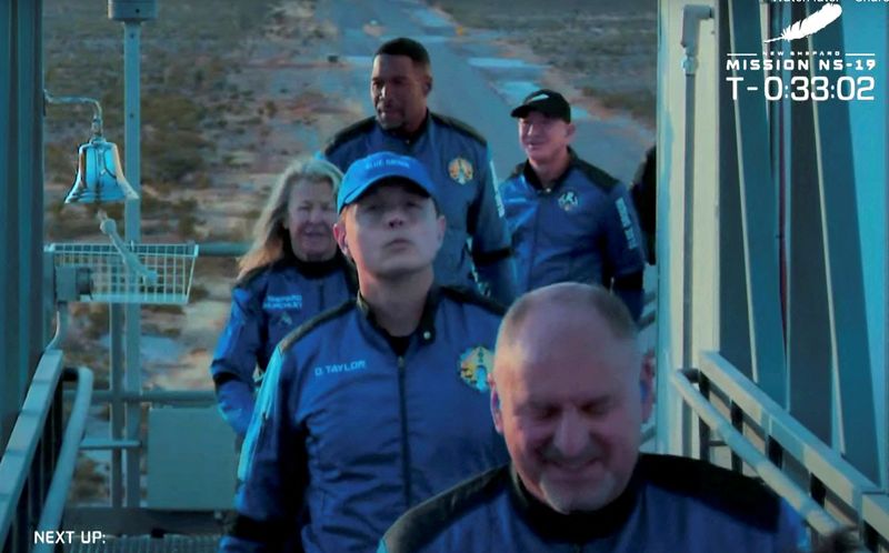 Billionaire Jeff Bezos, founder of e-commerce company Amazon walks behind the crew of a scheduled flight before they board Blue Origin's New Shepard rocket near Van Horn, Texas, Saturday.