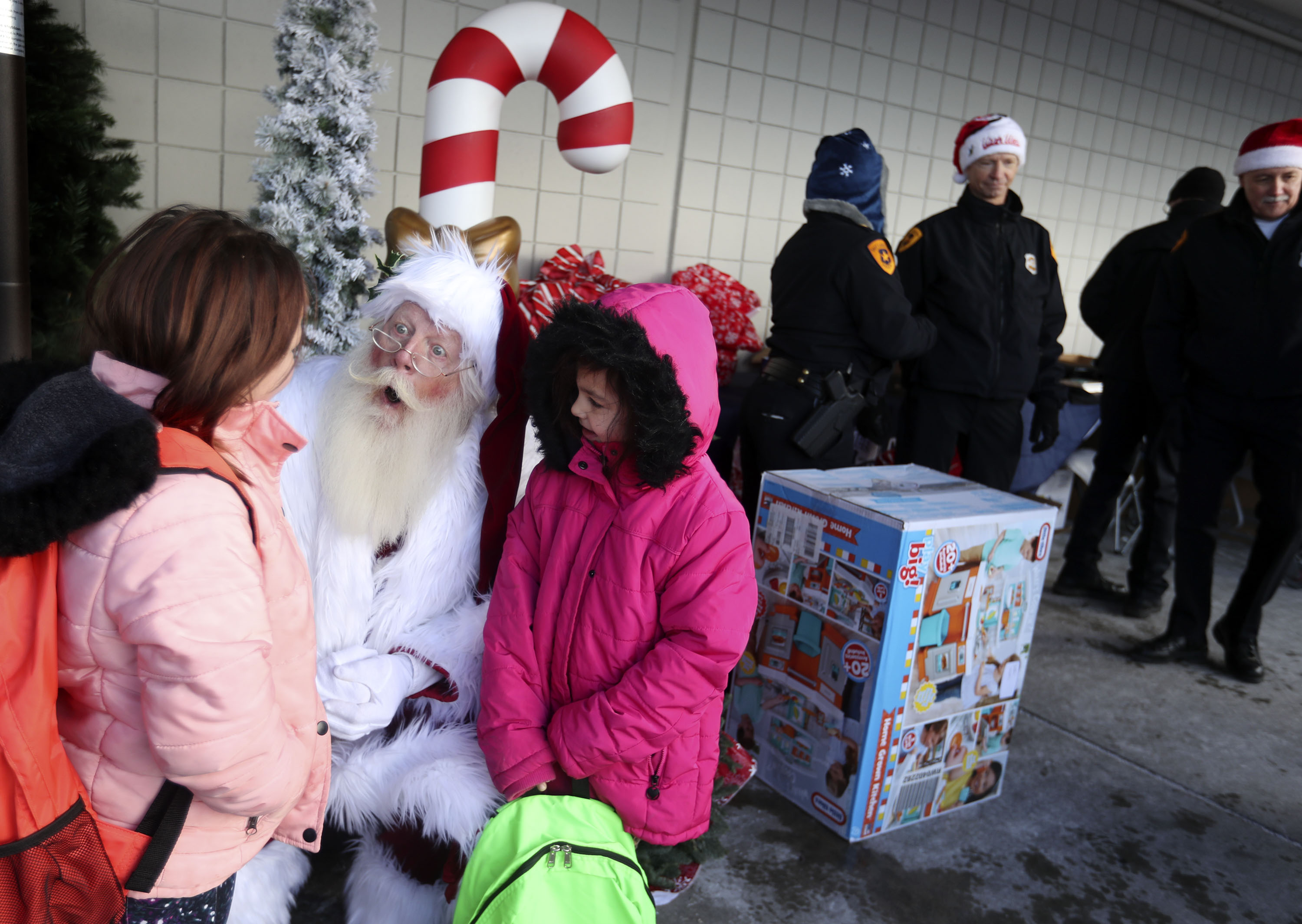 Sisters Camille and Jennifer Norton talk to Santa Dallas Nessen at the Salt Lake City Police Department’s annual holiday Police Pay-it-Forward event at Walmart in Salt Lake City on Saturday. Fifty-five children completed a holiday wish list and sent it to the Salt Lake City Police Department and the community outreach team shopped for each of the children and wrapped the gifts.