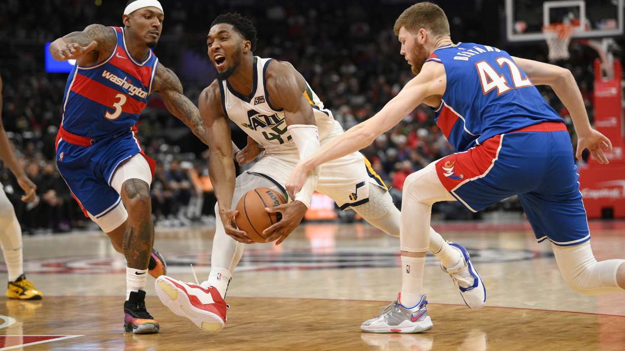 Utah Jazz guard Donovan Mitchell (45) drives to the basket against Washington Wizards guard Bradley Beal (3) and forward Davis Bertans (42) during the first half of an NBA basketball game Saturday, Dec. 11, 2021, in Washington.