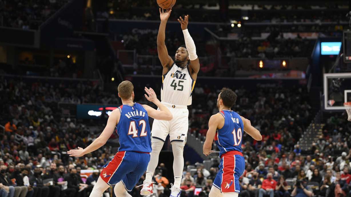Utah Jazz guard Donovan Mitchell (45) shoots against Washington Wizards forward Davis Bertans (42) and guard Raul Neto (19) during the first half of an NBA basketball game Saturday, Dec. 11, 2021, in Washington.