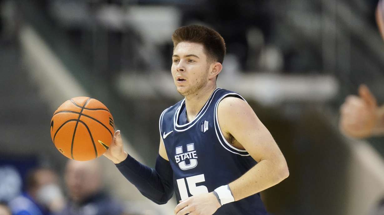 Utah State guard Rylan Jones (15) brings the ball up court in the first half during an NCAA college basketball game against BYU Wednesday, Dec. 8, 2021, in Provo, Utah.