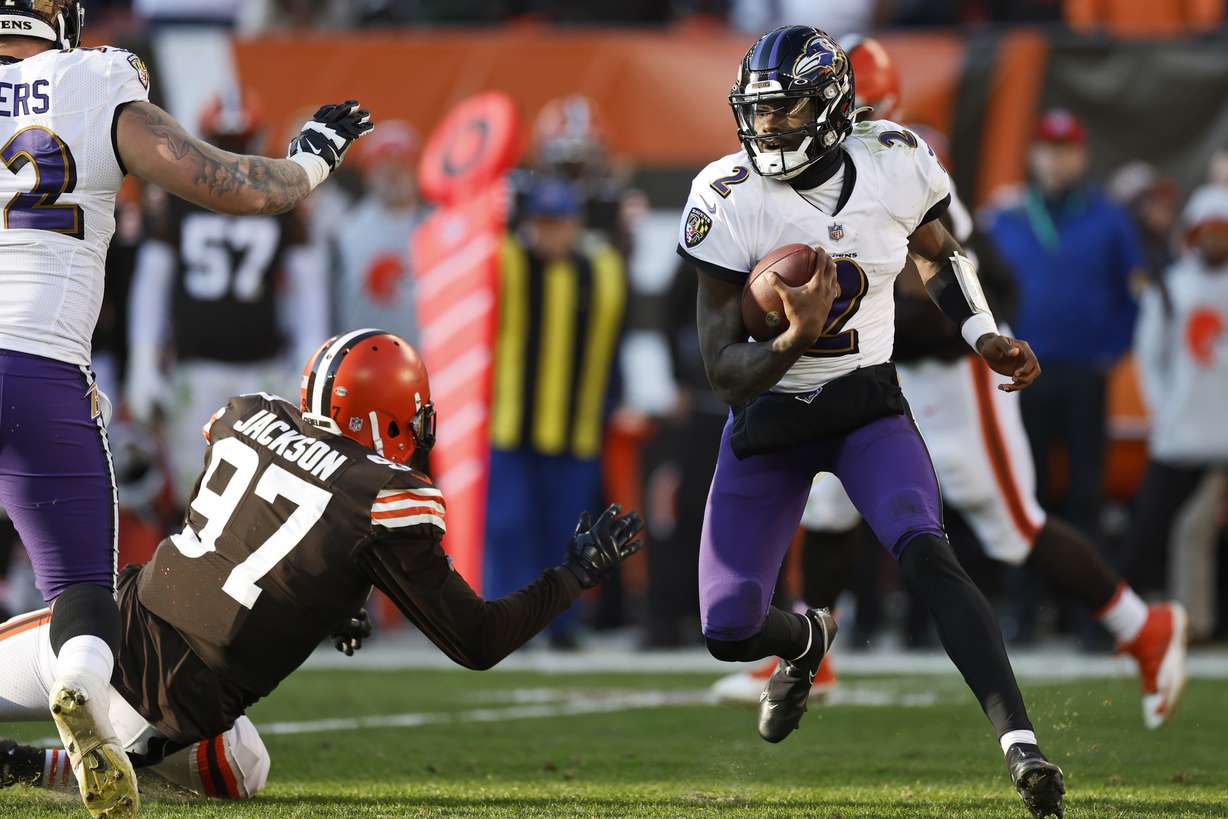 Baltimore Ravens quarterback Tyler Huntley (2) scrambles against Cleveland Browns defensive tackle Malik Jackson (97) during the second half of an NFL football game, Sunday, Dec. 12, 2021, in Cleveland.