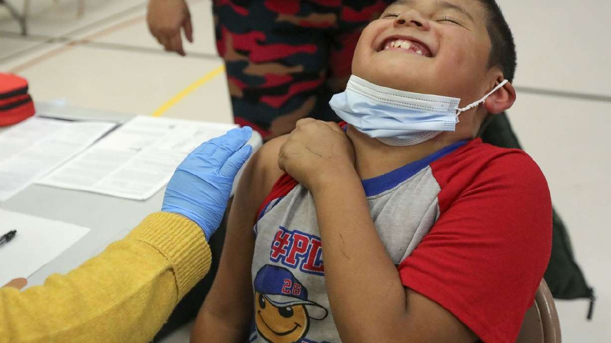 Angel Aguilar, 8, laughs before getting a COVID-19 vaccination at Hillsdale Elementary School in West Valley City on Nov. 8.