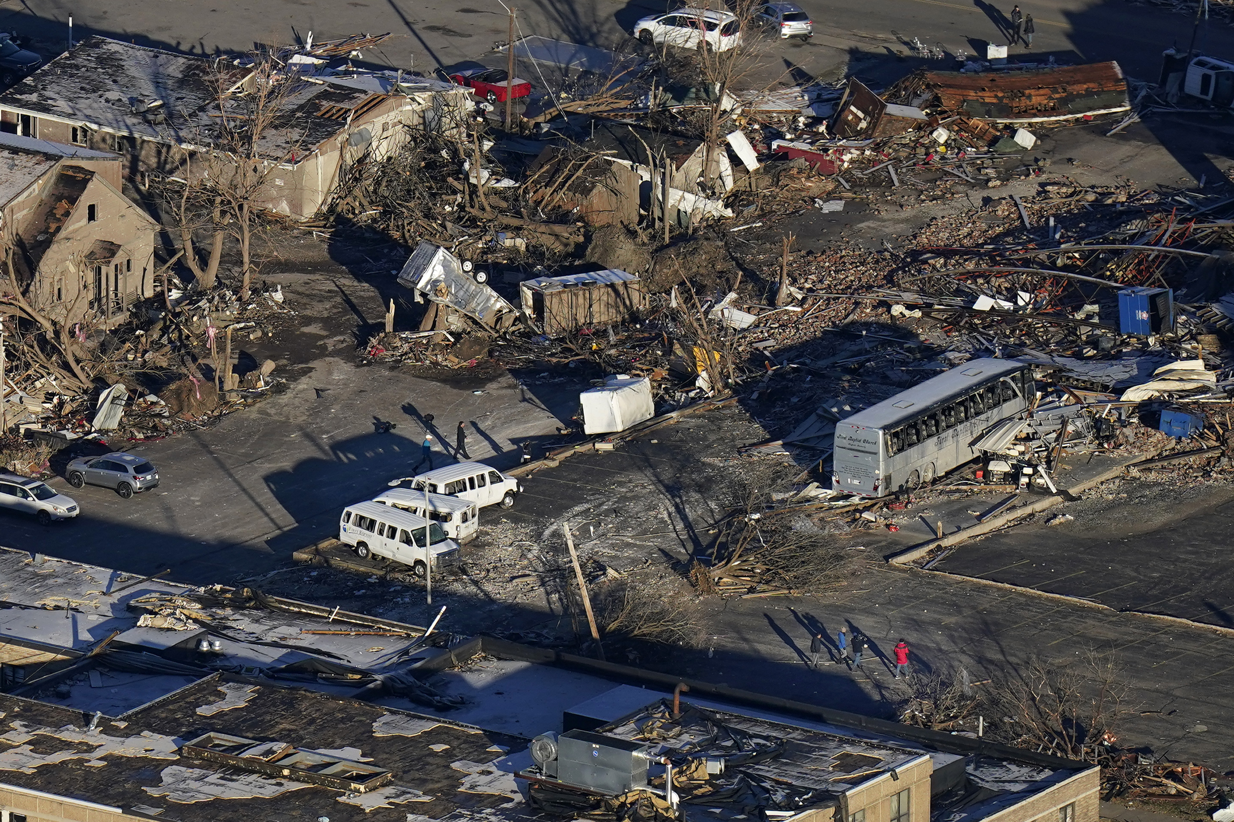 In a view from this aerial photo, people walk amidst destruction from a recent tornado in downtown Mayfield, Ky., Sunday.
