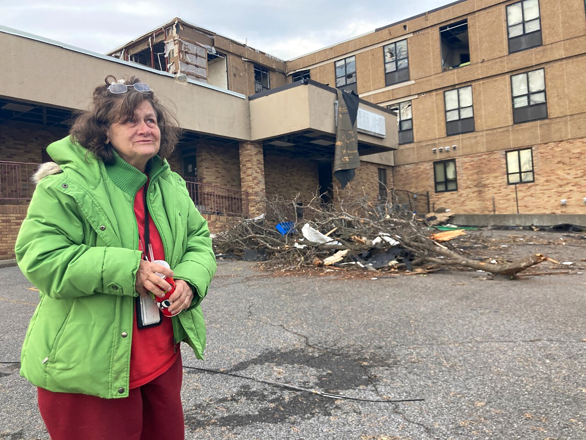 Judy Burton stands outside her apartment building, which was severely damaged in Friday's tornados, in Mayfield, Ky., Sunday.