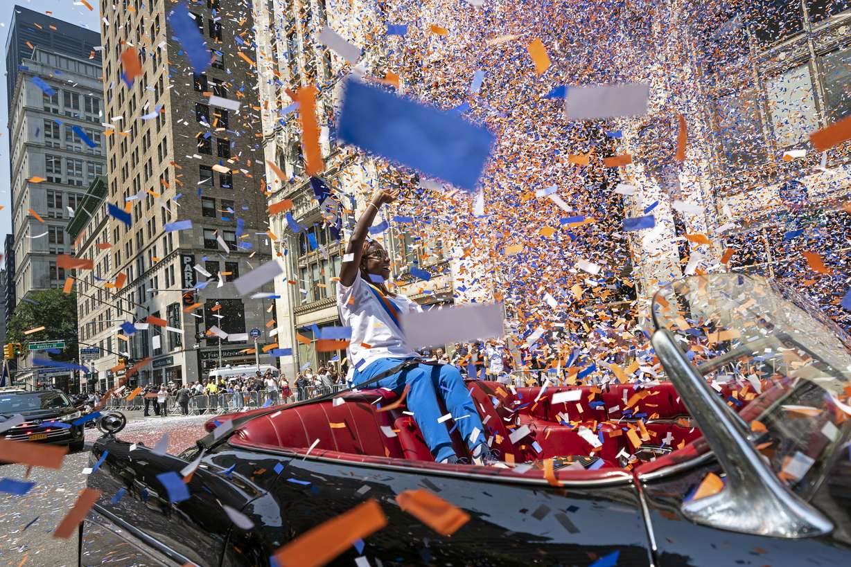 Grand marshal Sandra Lindsay, a health care worker who was the first person in the country to get a COVID-19 vaccine shot, waves to spectators as she leads marchers through the Financial District as confetti falls during a parade honoring essential workers for their efforts in getting New York City through the COVID-19 pandemic, July 7, in New York.