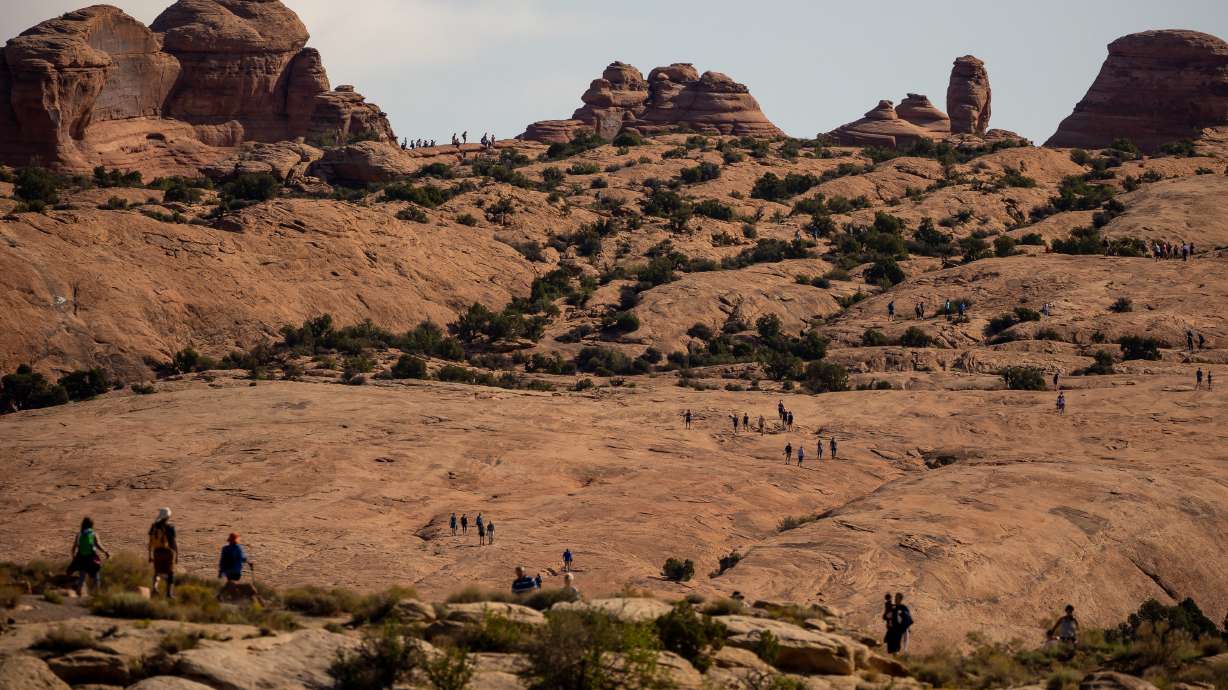 Visitors to Arches National Park make the hike to and from Delicate Arch, one of the park’s most popular attractions, on Sunday, Sept. 19, 2021.