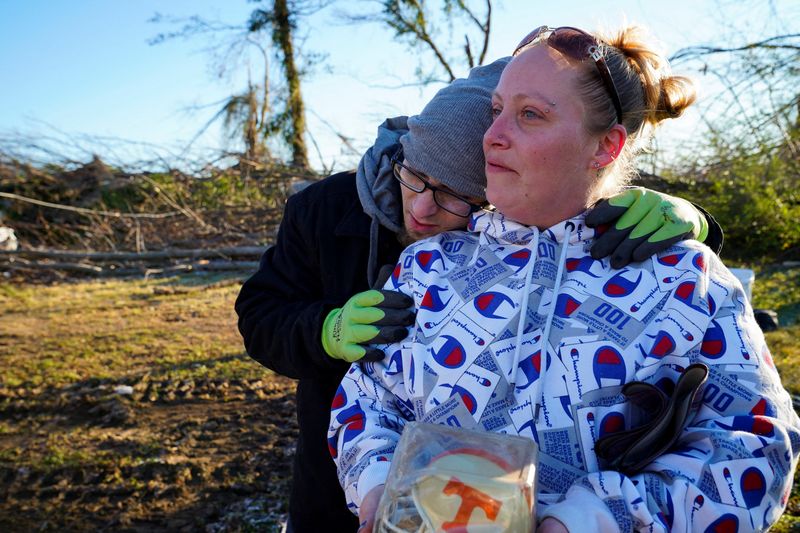 Jeremiah Barker, 37, embraces his fiance, Terra Utley, 32, while looking out at the pile of debris where their home once stood in the aftermath of a tornado in Mayfield, Kentucky, Monday.