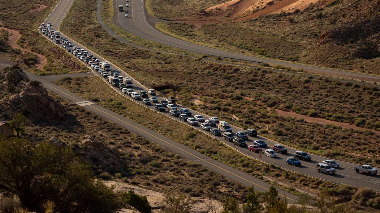 The entrance to Arches National Park, outside of Moab, Utah, begins to back up with visitors on Sunday, Sept. 19, 2021. Arches was one of the four national parks in the state that broke a visitation record last year.