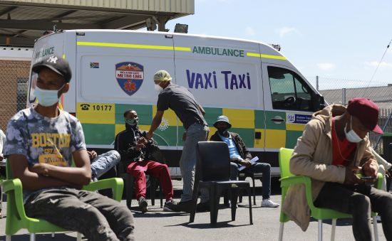 People wait to be vaccinated by a member of the Western Cape Metro EMS at a mobile "Vaxi Taxi" which is an ambulance converted into a mobile COVID-19 vaccination site in Blackheath in Cape Town, South Africa, Tuesday.