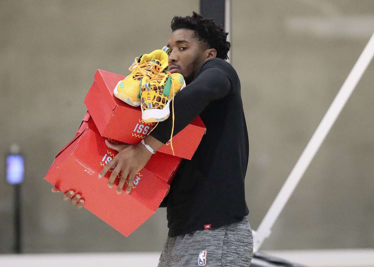 Utah Jazz guard Donovan Mitchell carries boxes of shoes after practicing at the Zions Bank Basketball Campus in Salt Lake City on Tuesday, Oct. 19, 2021.