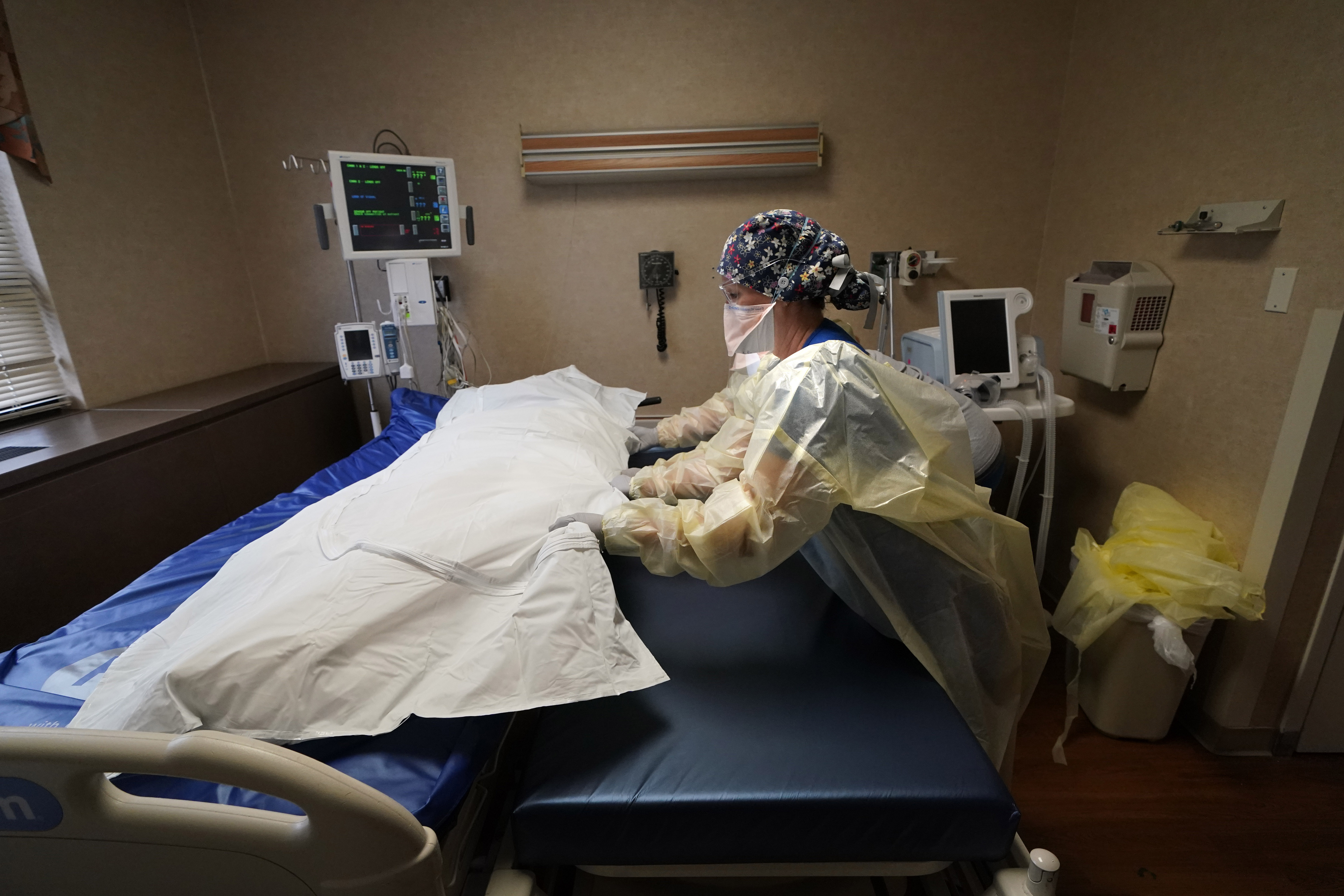 Medical staff move a COVID-19 patient who died onto a gurney to hand off to a funeral home van, at the Willis-Knighton Medical Center in Shreveport, La., Aug. 18.