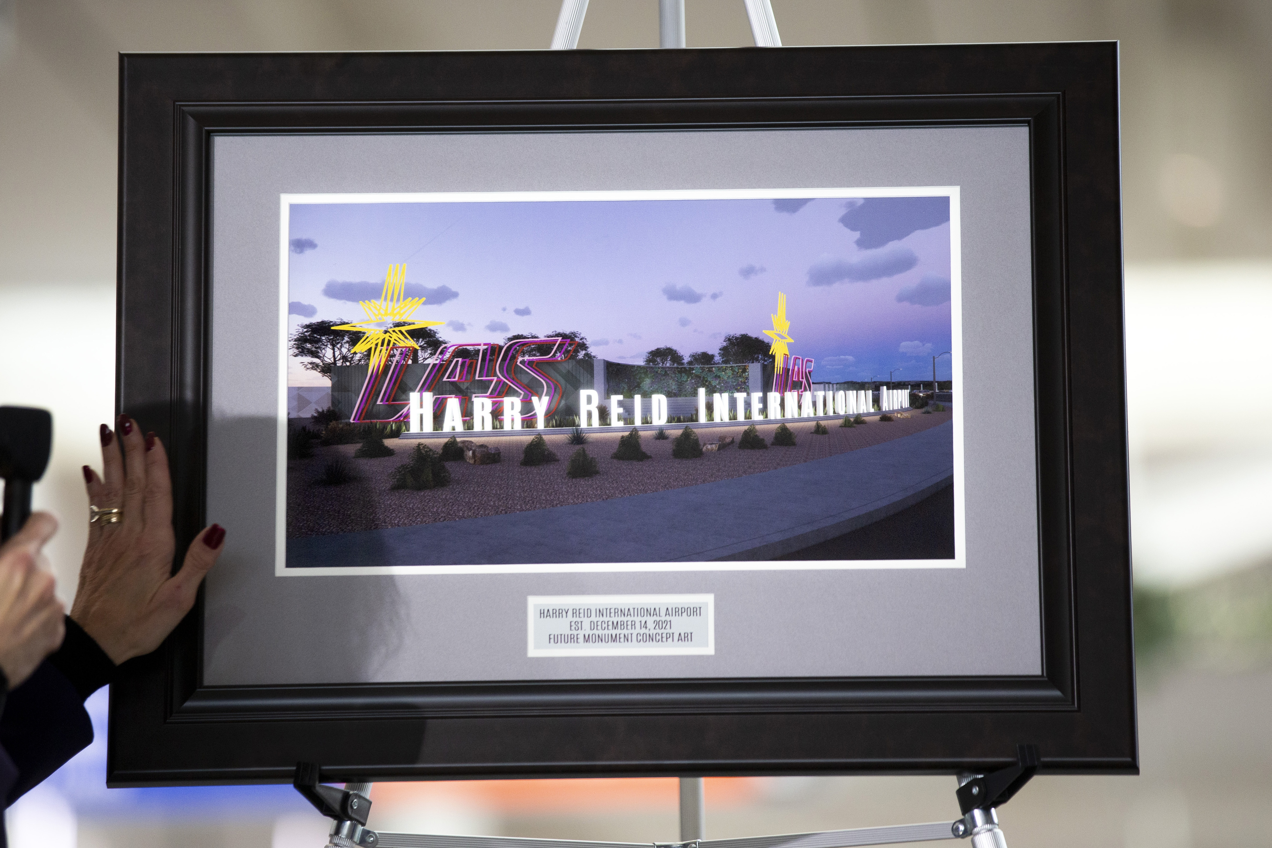 Clark County Director of Aviation Rosemary Vassiliades presents a framed illustration of proposed airport signage during the official renaming of McCarran International Airport to Harry Reid International Airport at the airport in Las Vegas on Dec. 14.