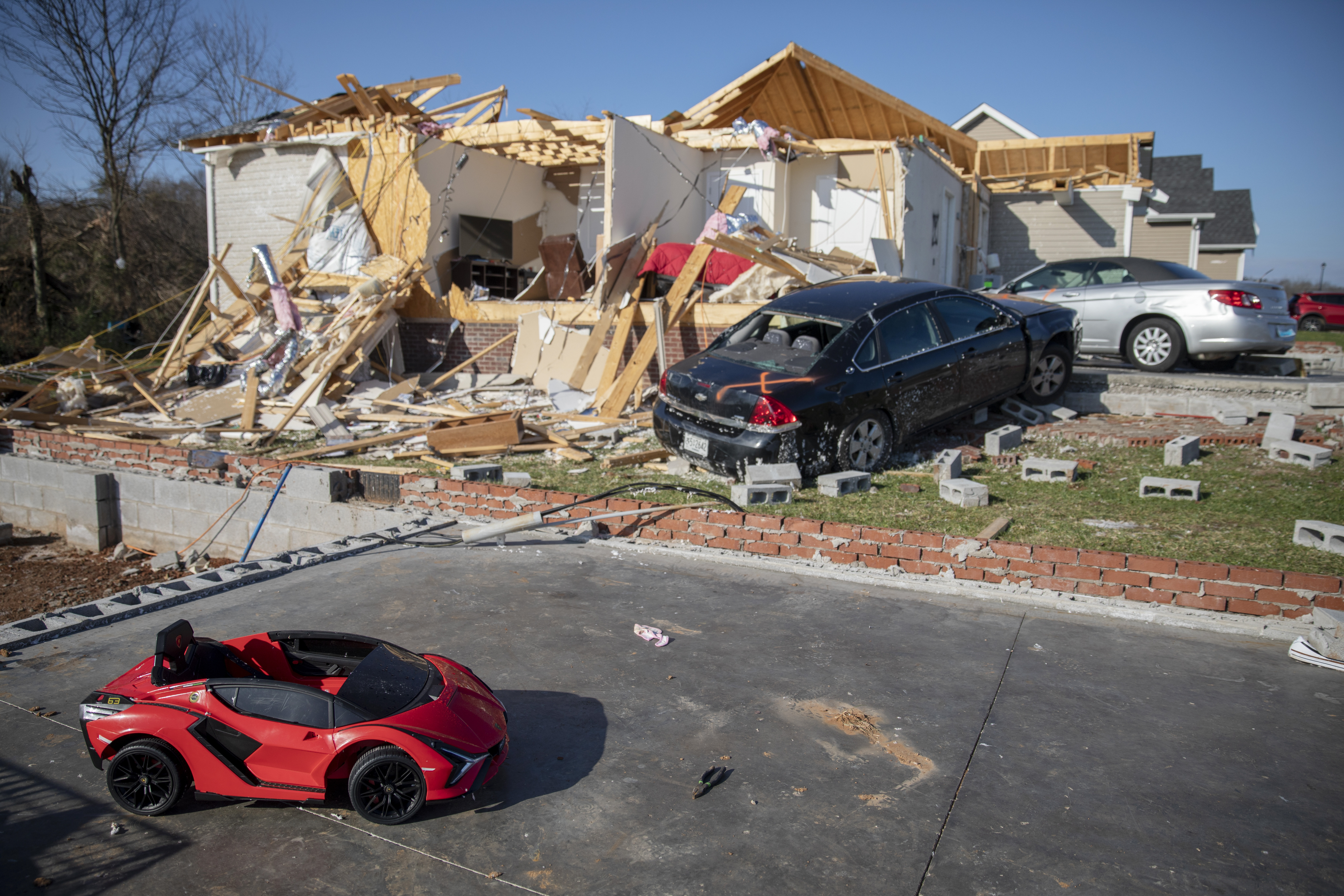A child's toy car sits near damaged cars and homes Tuesday, in Bowling Green, Ky. When a tornado touched down in Bowling Green in the middle of the night, its violence was centered on a friendly subdivision. Fourteen people died in a few blocks, 11 of them on a single street. Entire families were lost, between them seven children, two of them infants.