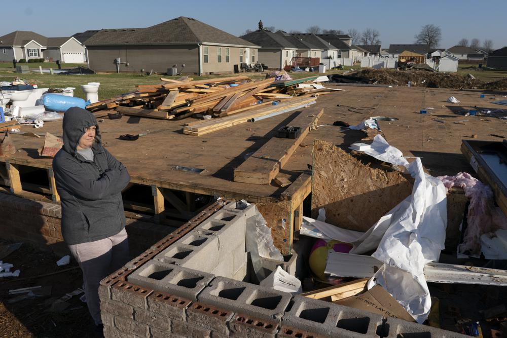 Ganimete Ademi surveys the debris from her daughter's house which was being built along Moss Creek Avenue in Bowling Green, Ky., Tuesday. The neighborhood was one of the hardest hit areas in the city after a tornado ripped through the city the previous weekend. Ademi, a 46-year-old grandmother, fled Kosovo in 1999 during the war, in which she lost her uncle and a nephew. Now she looks around her own neighborhood. “I turn my memory back to 22 years ago,” she said.