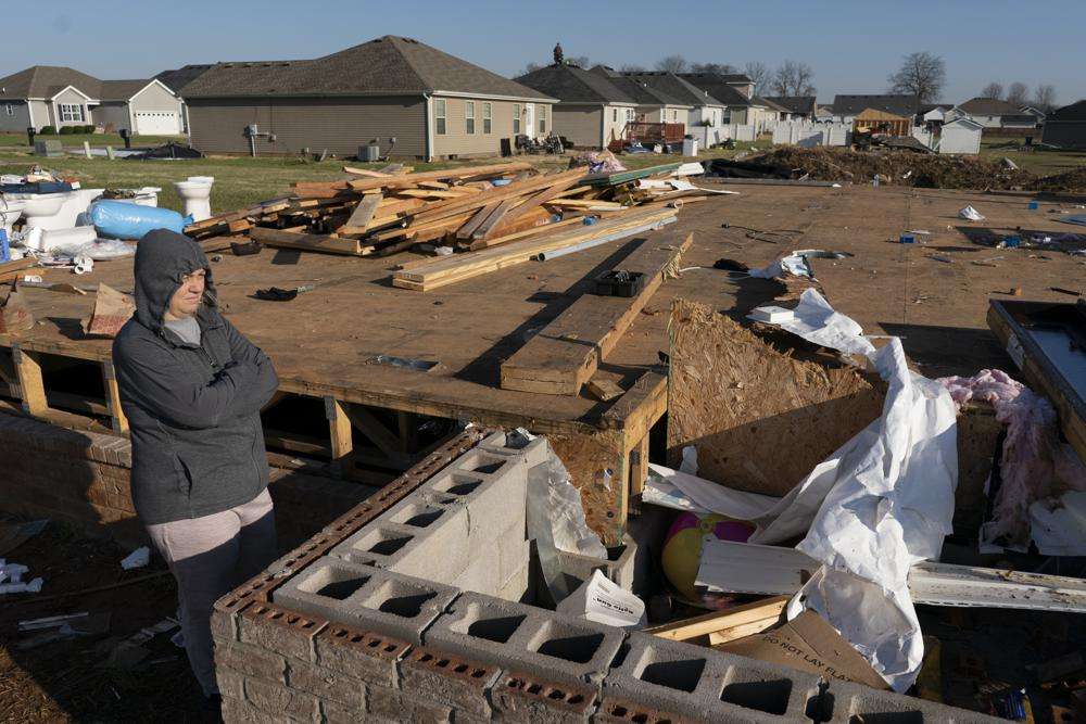 Ganimete Ademi surveys the debris from her daughter's house which was being built along Moss Creek Avenue in Bowling Green, Ky., Tuesday. The neighborhood was one of the hardest hit areas in the city after a tornado ripped through the city the previous weekend. Ademi, a 46-year-old grandmother, fled Kosovo in 1999 during the war, in which she lost her uncle and a nephew. Now she looks around her own neighborhood. “I turn my memory back to 22 years ago,” she said.