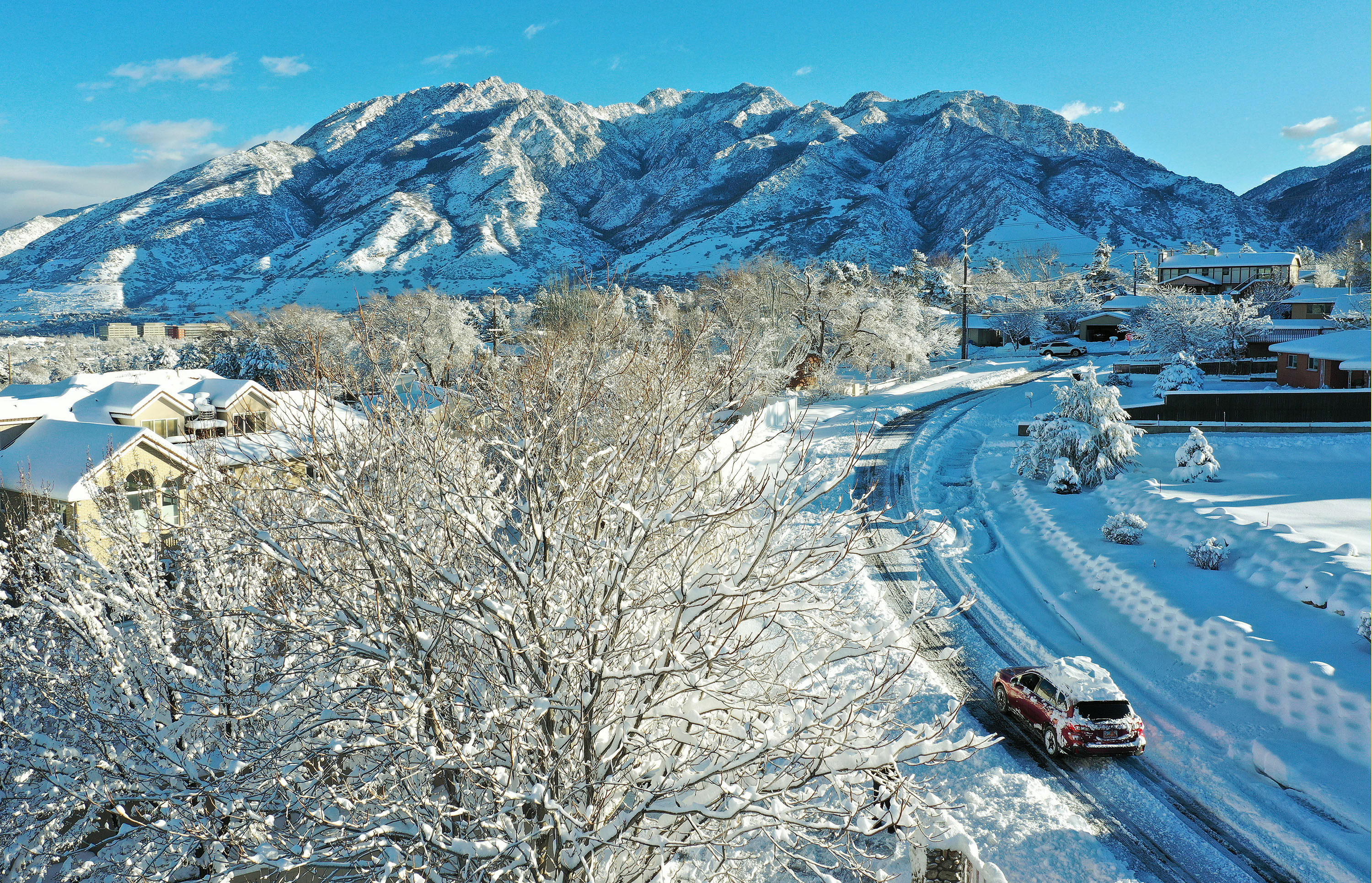 A motorist drives on a plowed street after a snowstorm in Cottonwood Heights on Wednesday.
