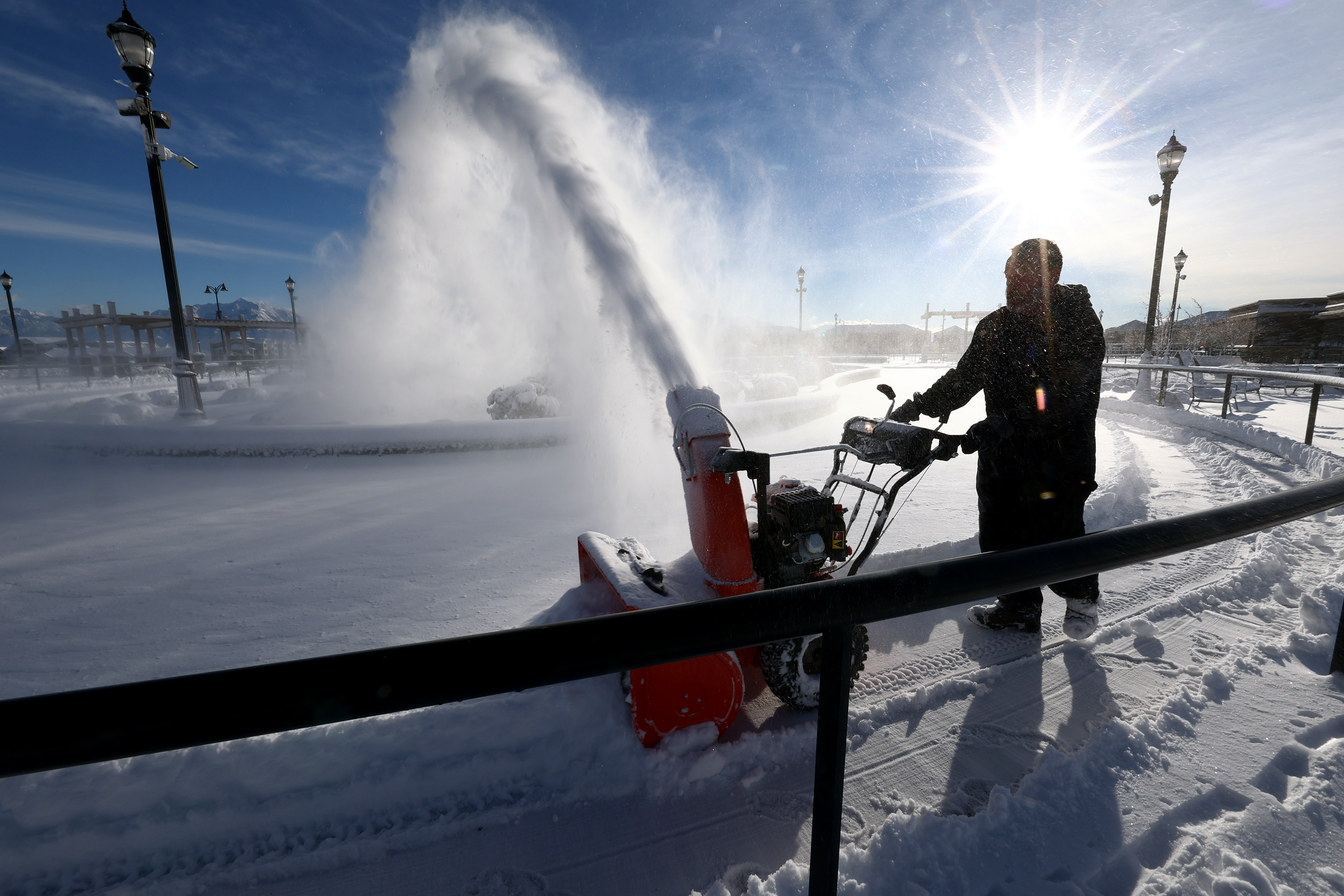 Jeff Kern removes snow from the ice skating area at the Herriman Towne Center on Wednesday.