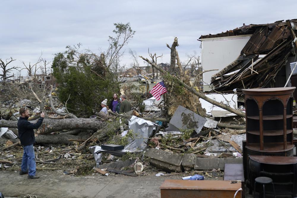 People survey storm damage from tornadoes and extreme weather in Mayfield, Ky., Wednesday.