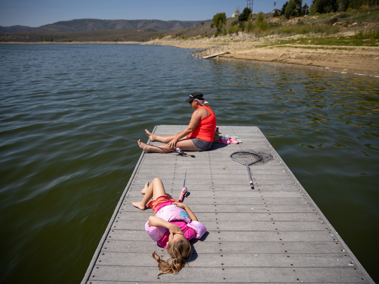 Presley Morse, 6, lies on a dock while fishing with her
mother, Jill Gilson, while they camp at Scofield State Park on
Friday, Aug. 27.