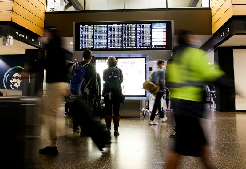 Travelers check a departures list at the ticketing level of Seattle-Tacoma International Airport before the Thanksgiving holiday in Seattle, Washington, on Nov. 24.