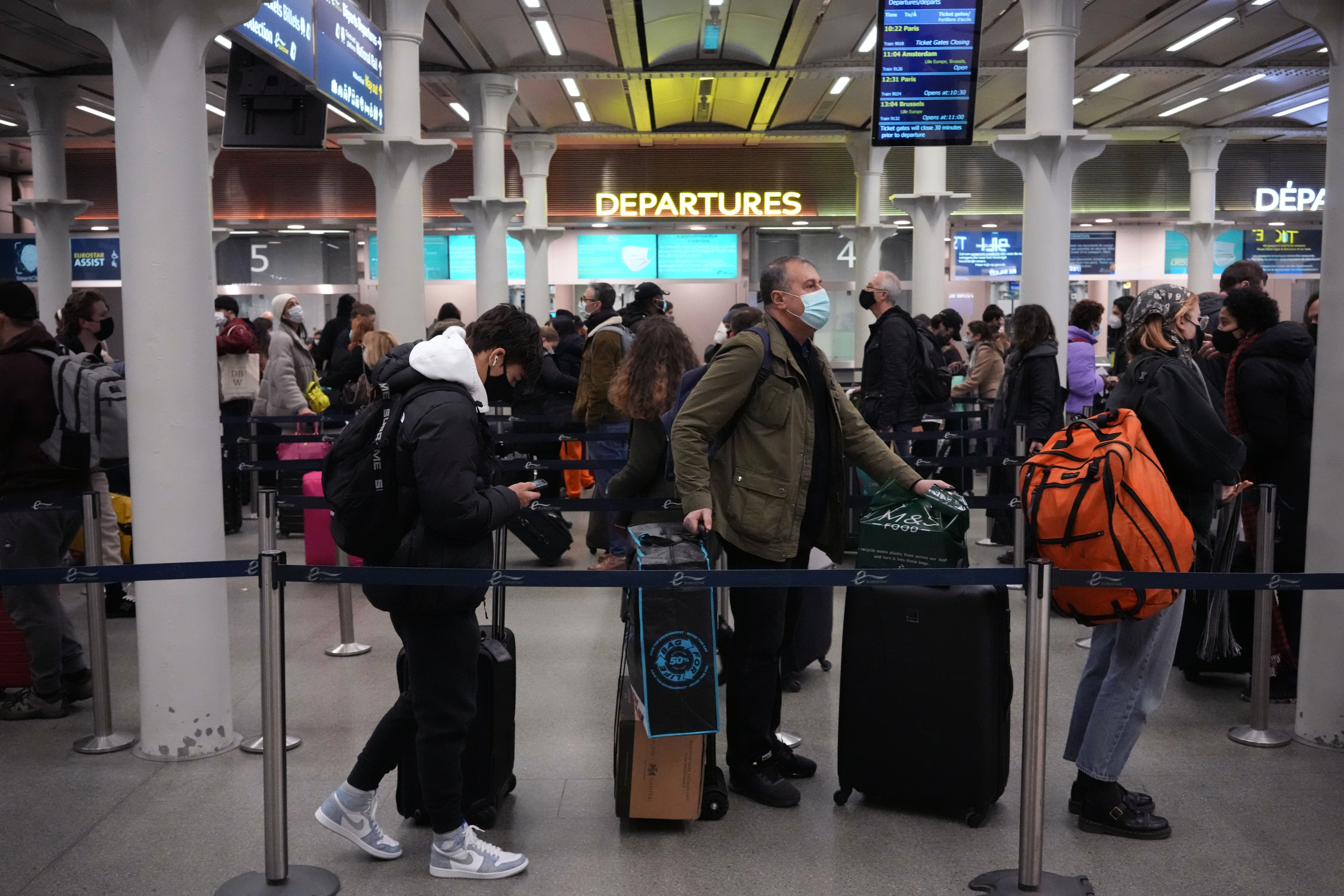 People queue up to travel on trains at London St. Pancras International rail station, in London, the Eurostar hub to travel to European countries including France, on Friday.