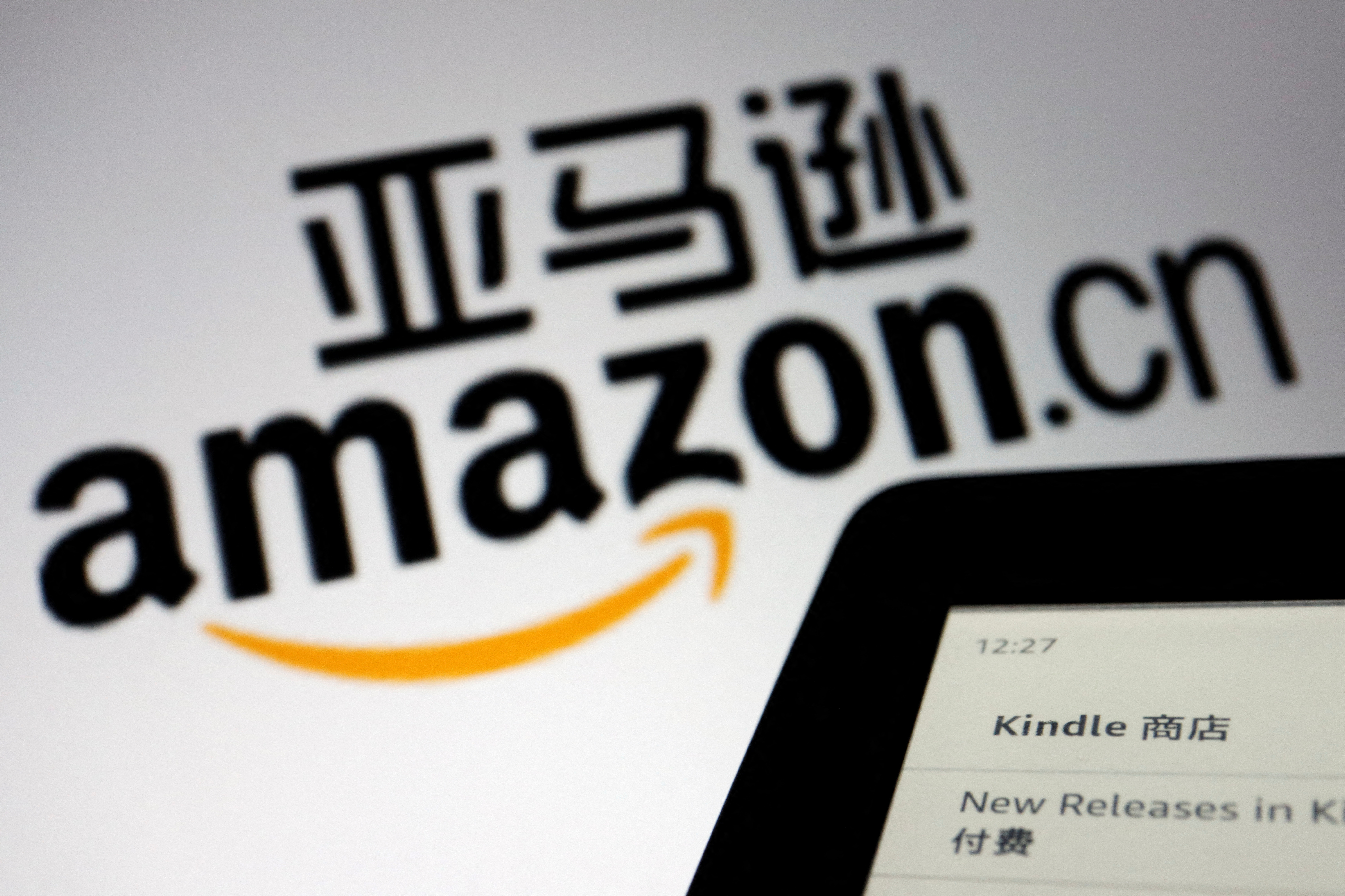 The sign of e-commerce website Amazon China is seen next to a Kindle e-reader displayed in this illustration , taken on Wednesday.