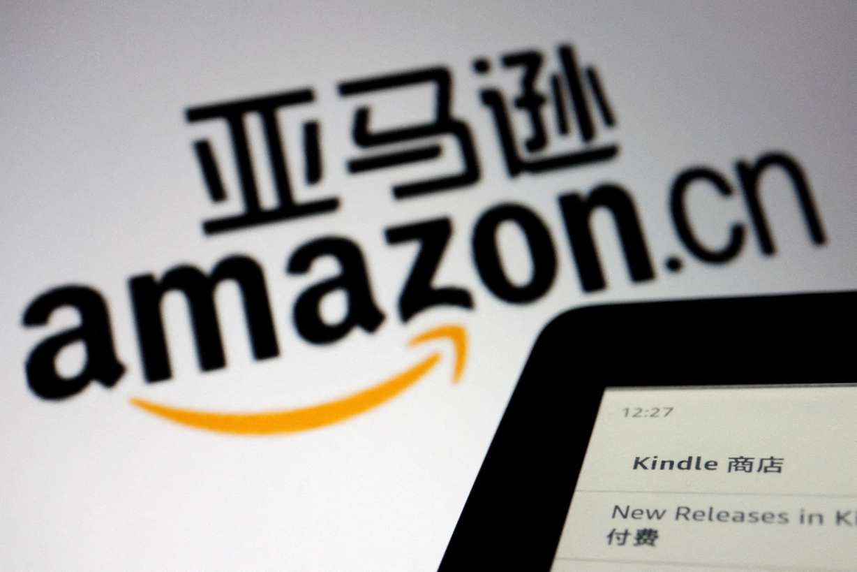 The sign of e-commerce website Amazon China is seen next to a Kindle e-reader displayed in this illustration , taken on Wednesday.