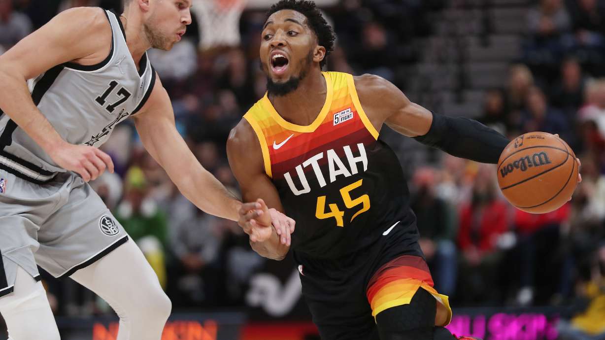 Utah Jazz guard Donovan Mitchell (45) drives ob San Antonio Spurs forward Doug McDermott (17) in Salt Lake City on Friday, Dec. 17, 2021.