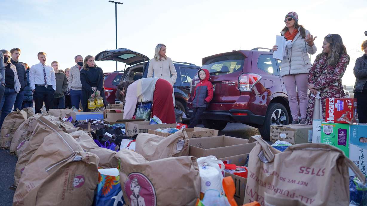 Jennifer Hua and Nazifa Rajabi address a group of volunteers in a shopping center parking lot in Midvale. They’re packing boxes to deliver to newly arrived Afghan families.