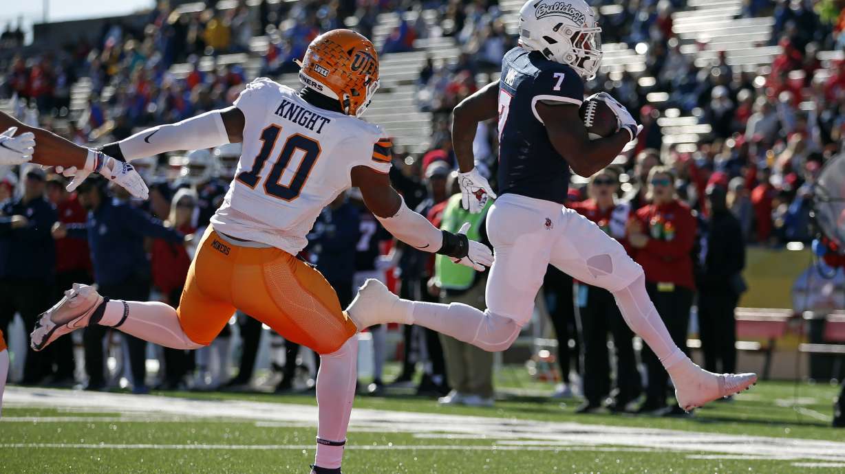 Fresno State running back Jordan Mims (7) leaps into the end zone ahead of UTEP linebacker Tyrice Knight (10) to score a touchdown during the first half of the New Mexico Bowl NCAA college football game Saturday, Dec. 18, 2021, in Albuquerque, N.M.