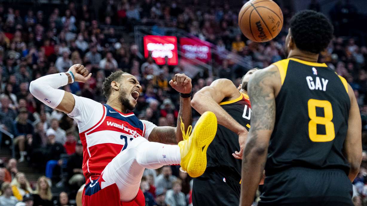 Washington Wizards center Daniel Gafford, left, reacts after dunking over Utah Jazz center Rudy Gobert, center, in the first half during an NBA basketball game Saturday, Dec. 18, 2021, in Salt Lake City.