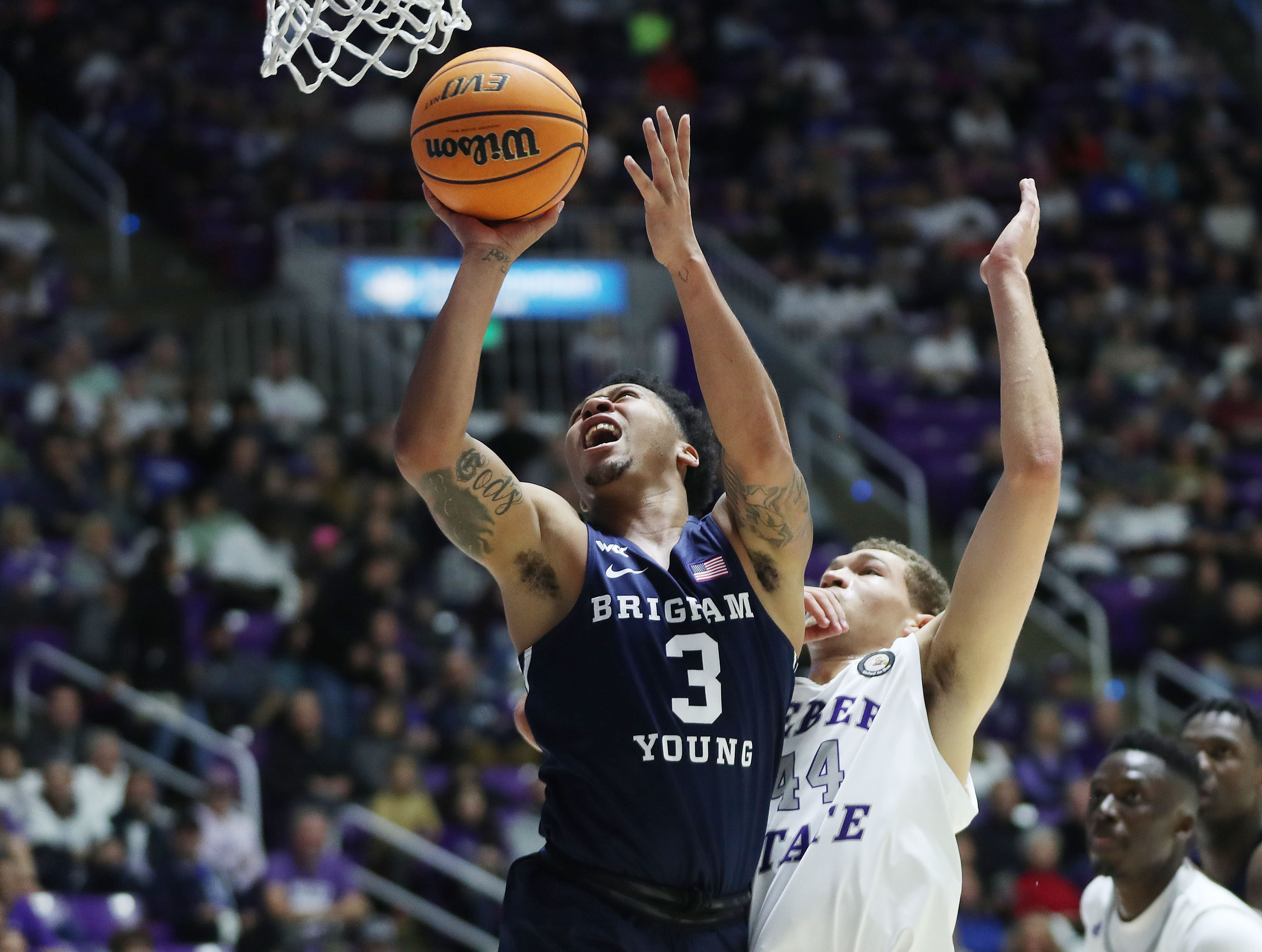 Brigham Young Cougars guard Te'Jon Lucas (3) drives on Weber State Wildcats forward Dyson Koehler (44) in Ogden on Saturday, Dec. 18, 2021. BYU won 89-71.
