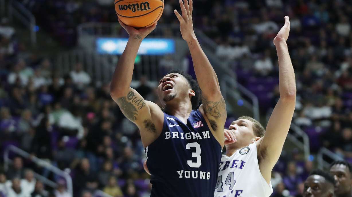 Brigham Young Cougars guard Te'Jon Lucas (3) drives on Weber State Wildcats forward Dyson Koehler (44) in Ogden on Saturday, Dec. 18, 2021. BYU won 89-71.