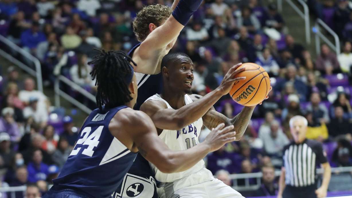 Weber State Wildcats guard Koby McEwen (15) is defended by Brigham Young Cougars forward Caleb Lohner (33) in Ogden on Saturday, Dec. 18, 2021. BYU won 89-71.