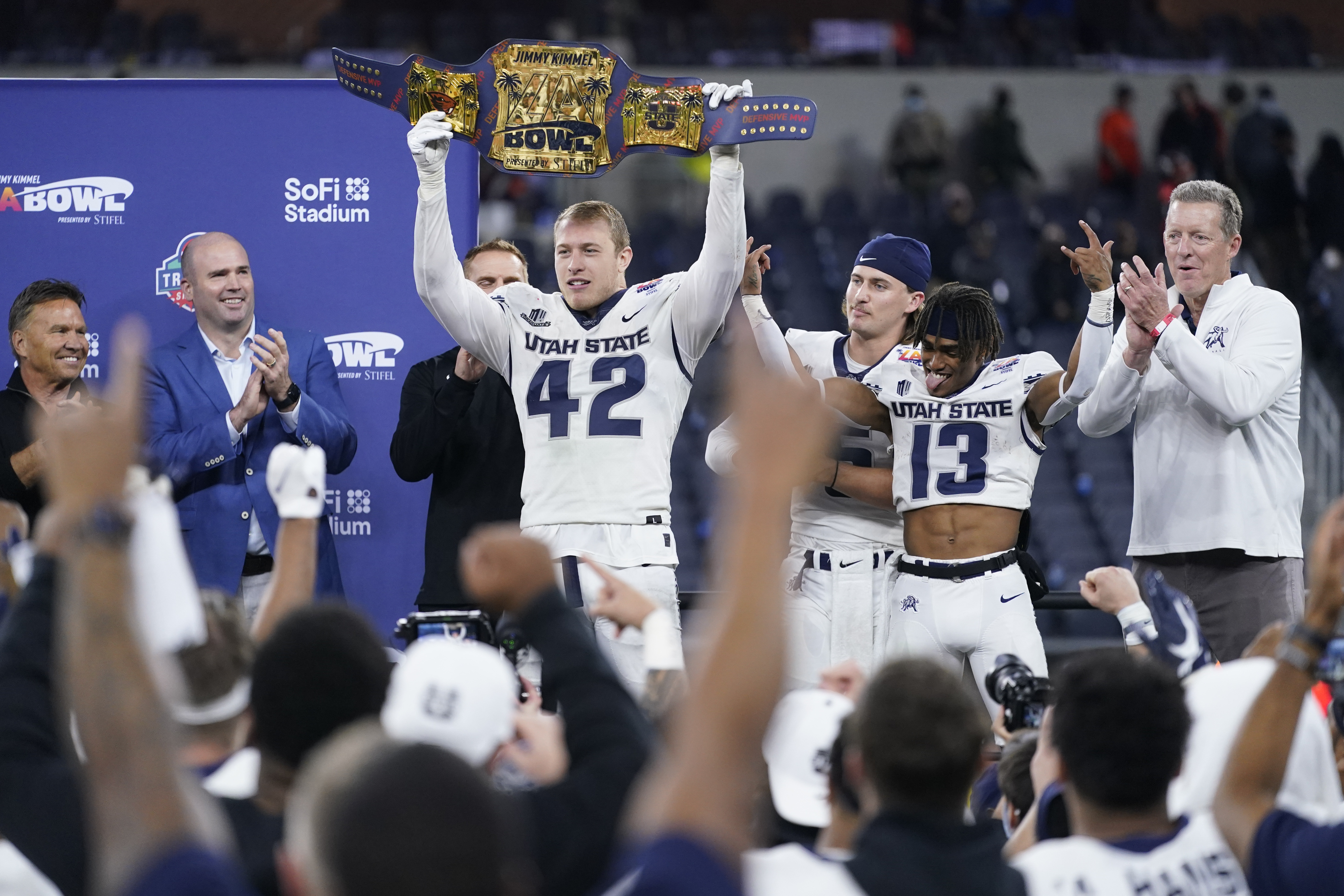 Utah State defensive end Nick Heninger (42) holds up a championship belt after they won the LA Bowl NCAA college football game 24-13 over Oregon State in Inglewood, Calif., Saturday, Dec. 18, 2021.