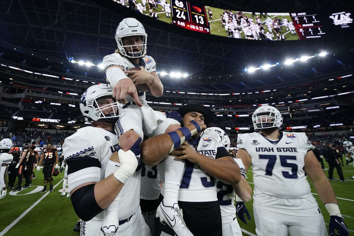 Utah State quarterback Cooper Legas (5) is hoisted on the shoulders of his teammates after they won the LA Bowl 24-13 over Oregon State in Inglewood, Calif., Saturday, Dec. 18.