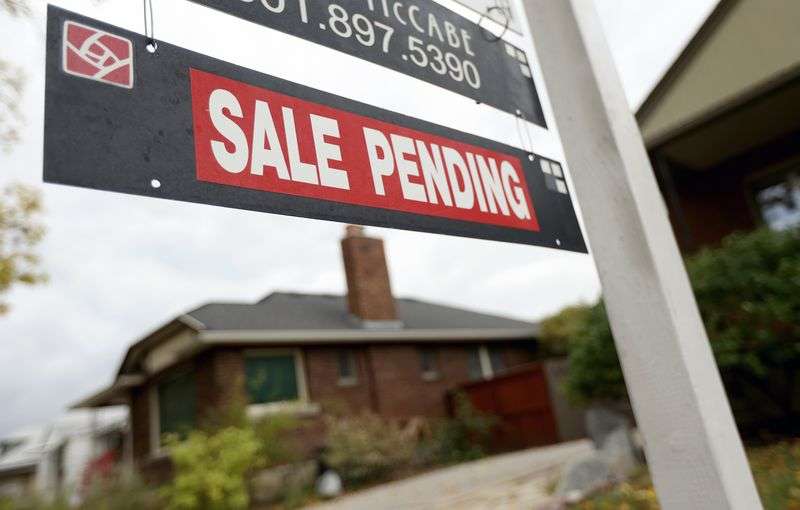 A "for sale” sign and "sale pending” sign are pictured
in Salt Lake City on Monday, Oct. 18.