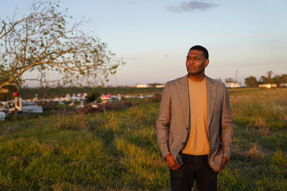 EPA Administrator Michael Regan poses for a photo near a cemetery in a neighborhood next to the Nu Star Energy oil storage tanks, after conducting a television interview, in St. James Parish, La., Nov. 16.