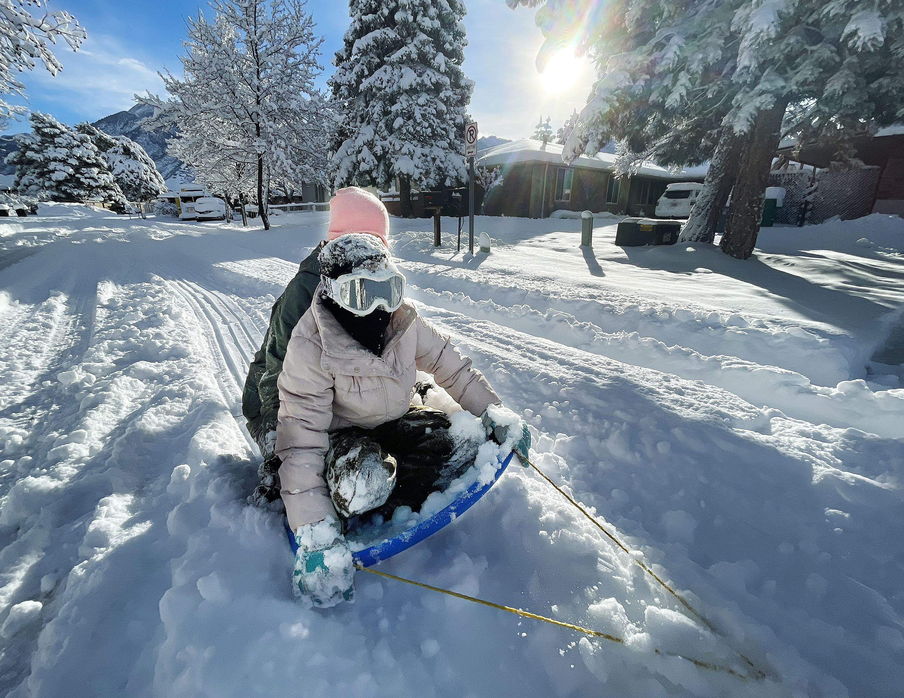 Naomi and Eva Mecham get a ride on their sled from their dad after a big snowstorm in Cottonwood Heights on Dec. 15. More snow, especially in Utah's mountains, is expected just ahead of Christmas.