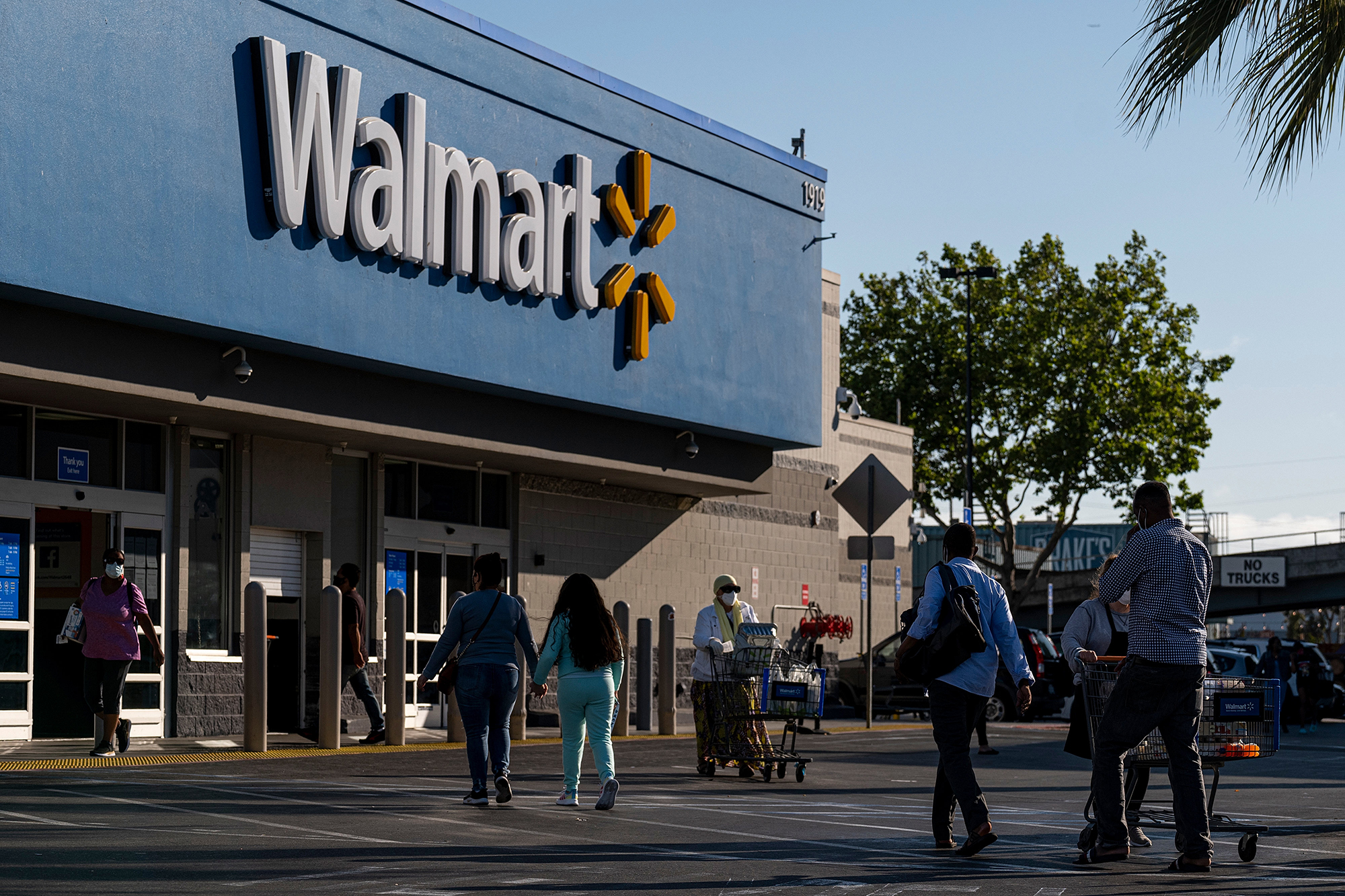 Shoppers walk in front of a Walmart store in San Leandro, Calif., May 13. Walmart is being sued for allegedly dumping hazardous items.