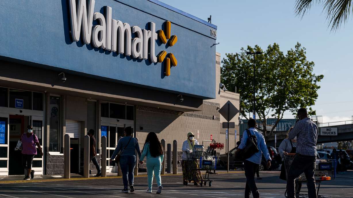 Shoppers walk in front of a Walmart store in San Leandro, Calif., May 13. Walmart is being sued for allegedly dumping hazardous items.