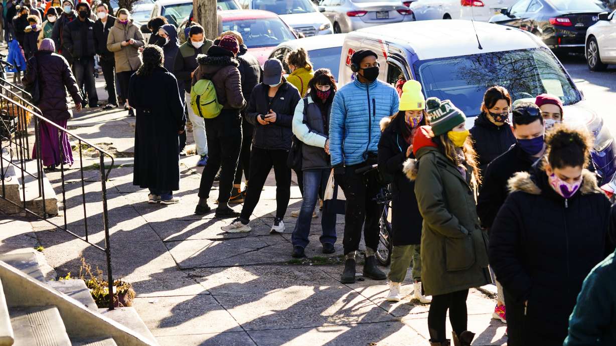 City residents wait in a line extending around the block to receive free at-home rapid COVID-19 test kits in Philadelphia, on Monday.